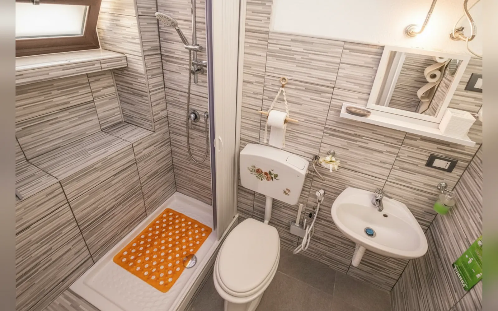 Il bagno con il piatto doccia, i sanitari e il rivestimento a righe
