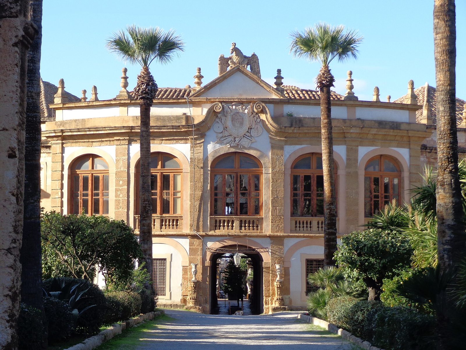 La facciata barocca di Villa Palagonia a Bagheria vista dal viale d'ingresso tra le palme