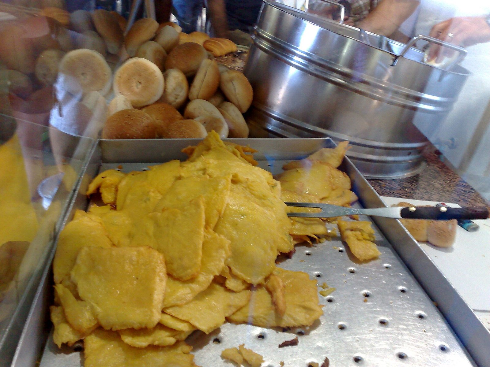 Un vassoio di panelle fritte appena preparate, con i panini al sesamo pronti sullo sfondo