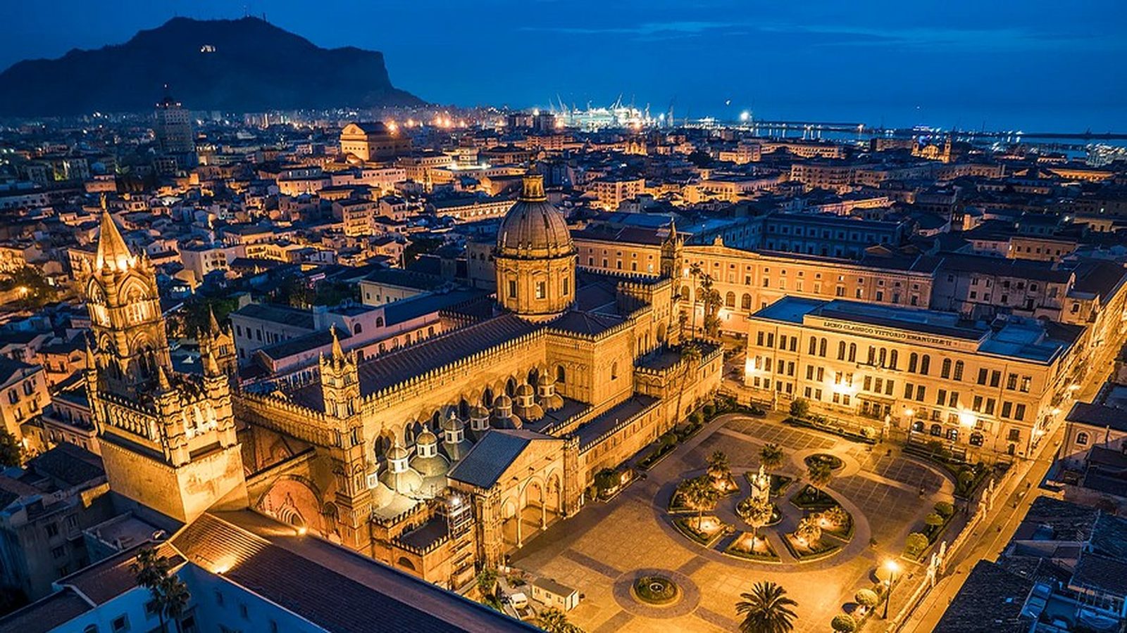 La Cattedrale di Palermo illuminata di sera, vista dall’alto in mezzo al centro storico