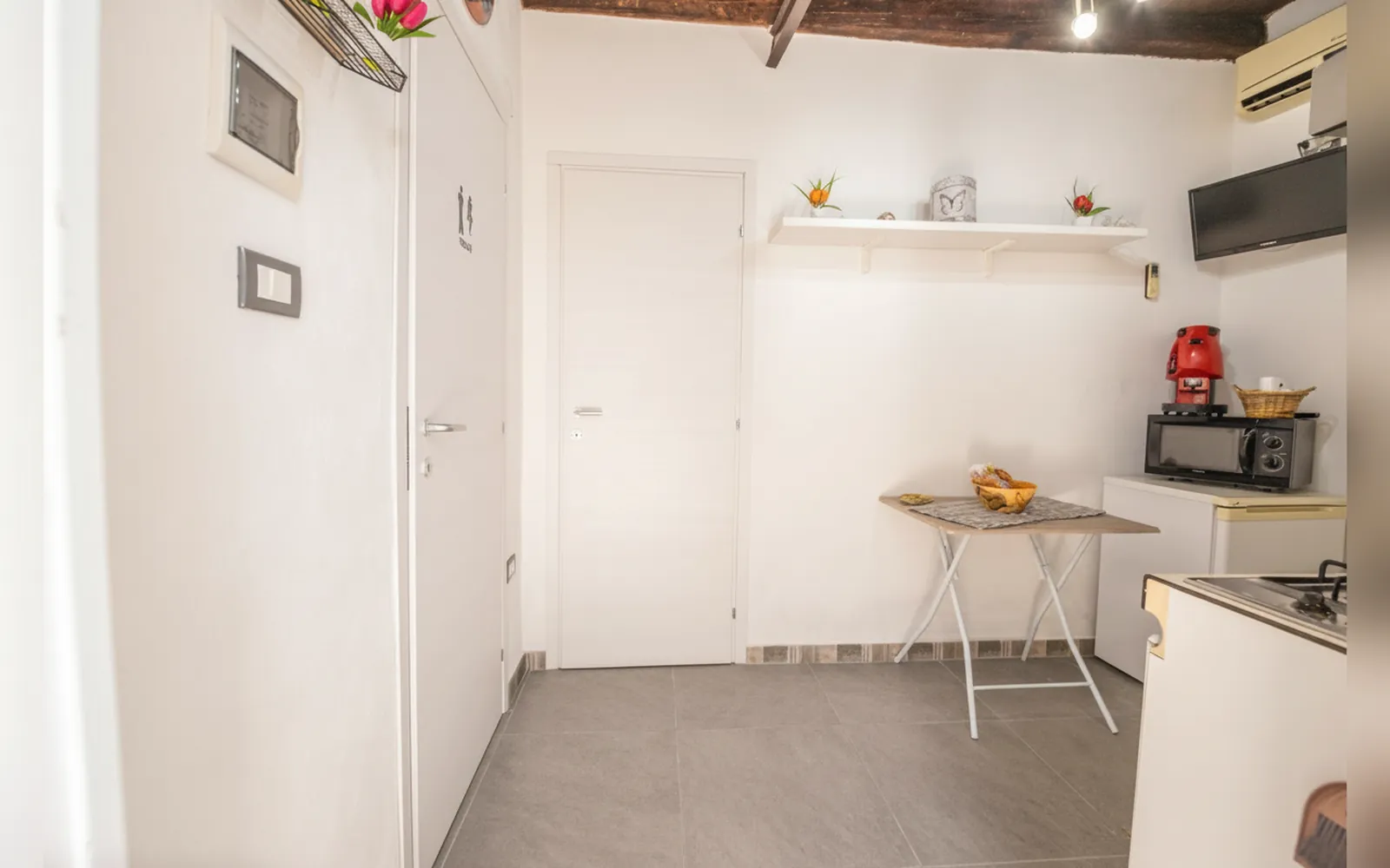 La zona cucina con il microonde, la macchina da caffè e il tavolino